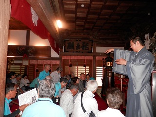 成顕寺で副住職から説明を受ける参加者たち