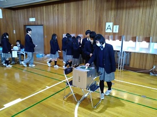 写真：投票を体験する生徒たち