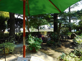 写真：庭園内のティーテーブルでお茶を楽しむ来館者