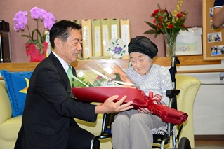 市長から花束を受け取る長谷川さんの写真