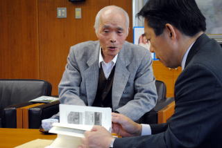 井崎市長に本を紹介する様子の写真