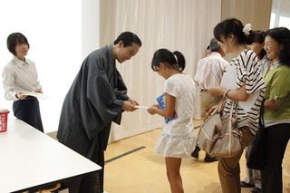 来場者に一筆箋を渡す中村さんの写真
