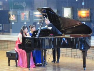 ピアニスト2人が集中してピアノを弾く写真
