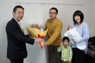 冨田さん夫妻に花束を渡す井崎市長の写真