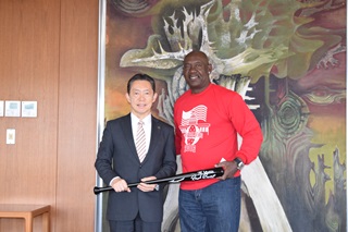井崎市長にバットを手渡すブライアントさんの写真