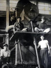 昭和30年ころ「日本鋳工第1工場、完成したショットブラストマシン前列左端が野能さん」の写真