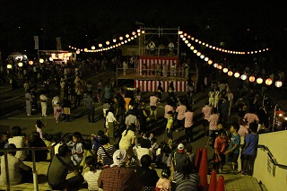 夜に盆踊りを楽しむ写真