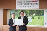 協定書を持つ井崎市長と菊池営業本部長の写真