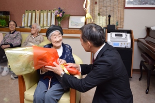 井崎市長から花束を受け取る長谷川さんの写真