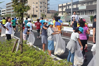 写真：ランナーから紙コップを受け取る児童たち