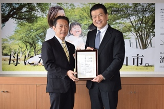 認定証を持つ市長と西川社長の写真