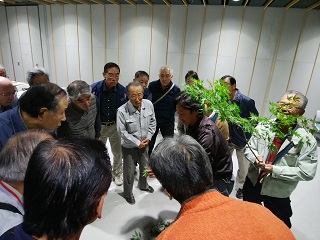 写真：参加者に庭木の解説をする高市高明社長ほか