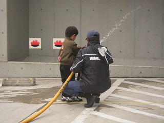 写真：放水体験を行うお子さん