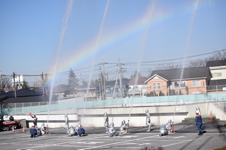 放水で空に虹がかかった写真