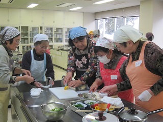 写真:栄養士に調理法を学ぶ参加者