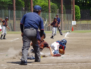 写真：ホームインで指される選手