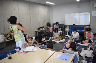 写真：いろはちゃんを抱えて講義するサチさん