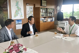 写真：歓談する長澤章裕社長と中根幹夫執行役員と井崎市長