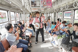 走る車内で演奏する青木さんらの写真