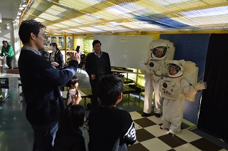 写真：宇宙服の試着を楽しむ親子