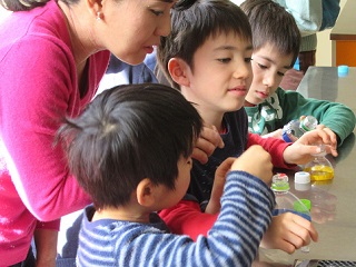 写真：ペットボトルで顕微鏡を作る子ども達