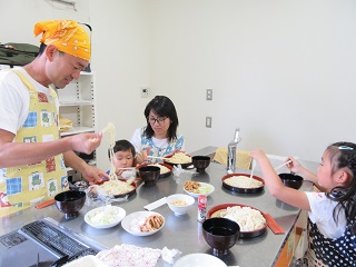 写真：笑顔でうどんを食べる様子