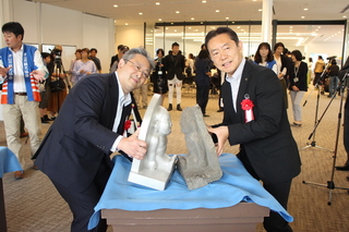写真：初代と二代目の足裏合わせをする志賀会長と井崎市長