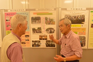 写真：活動状況の展示を説明する会員