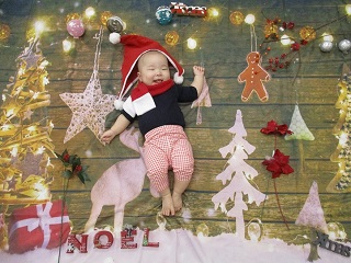 写真＝クリスマスの背景で撮影する赤ちゃん