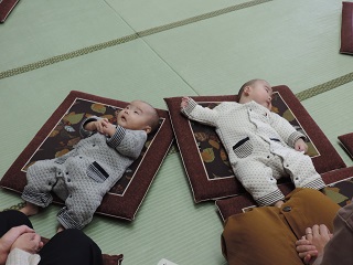 写真：座布団の上で横になる赤ちゃん
