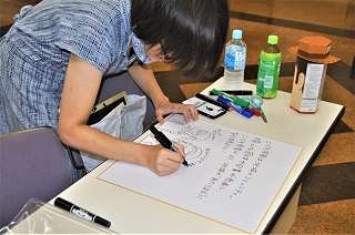写真：サインに笑顔で応じる橋本さん