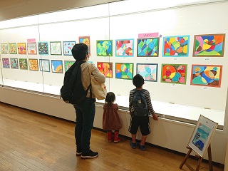 展示された作品を鑑賞する親子連れ