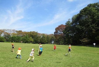 子ども達が元気に芝生広場で遊んでいます。
