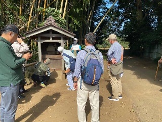 利根運河大師を巡る参加者　お堂の中をのぞく人と少し離れたところからお堂を見る人の写真