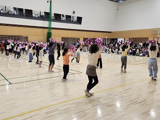 チアダンス講習会でチアダンスをしている多くの参加者の写真