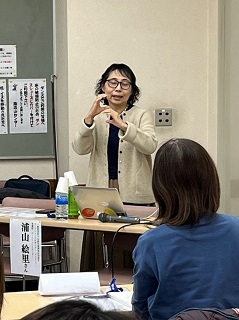 第3回の講師、浦山絵里さんがパソコンが置かれた机の前に立ち話す写真