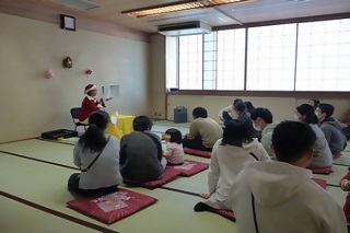 和室で紙芝居を見ている親子の様子の写真