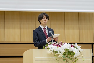 壇上で話す成人式実行委員の牧田さんの写真