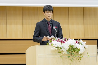 壇上で話す成人式実行委員長の木澤さんの写真