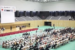 2階から撮影された会場全体の写真。多くのパイプ椅子が用意され、参加者が座っている様子。