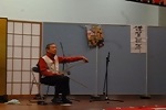 舞台上で西洋のこぎりを弓で弾いているのこ木本さんの写真