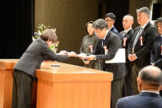 代表の小林さんが賞状を受け取る様子