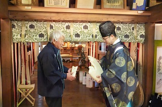 写真：餅の割れ具合を確認する立会人と禰宜