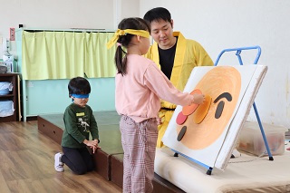 子どもが目隠しをして福笑いをしている様子