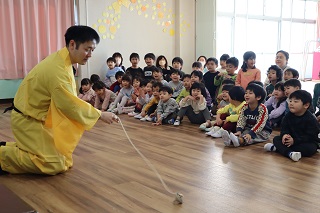 保育士が子ども達の前でコマ回しをしている
