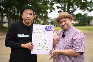 流山市の地図が描かれたフリップを持つナイツ塙さんと、話すコンパス西本さんの写真