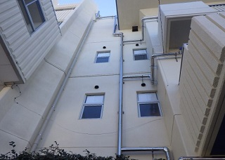 校舎の外壁にある給水管の写真
