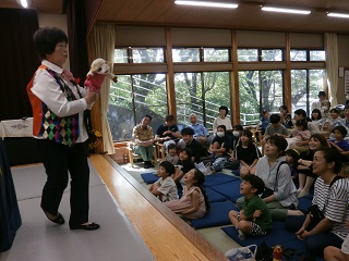 小さな牛のぬいぐるみが来場者にむかって話している写真