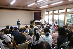副会長が来場者の前で挨拶をしている写真