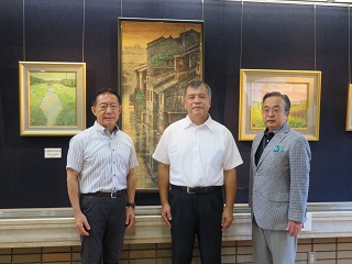 後藤紳也さんと市長、副市長が絵を背に写真撮影